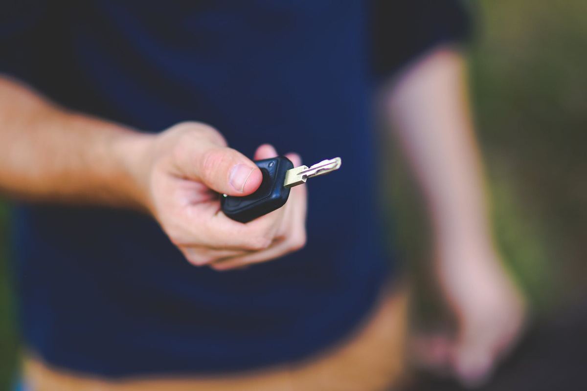 Een hand reikt een autosleutel aan