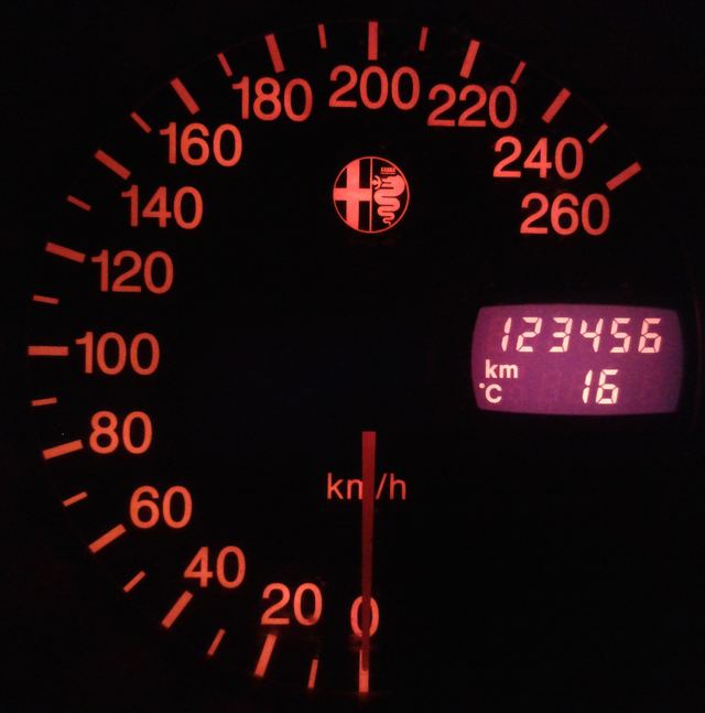 Teller van een wagen met een rode schaal en een kilometerstand van 123456